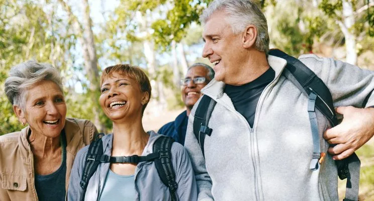 group of 4 middle aged people backpacking on trail