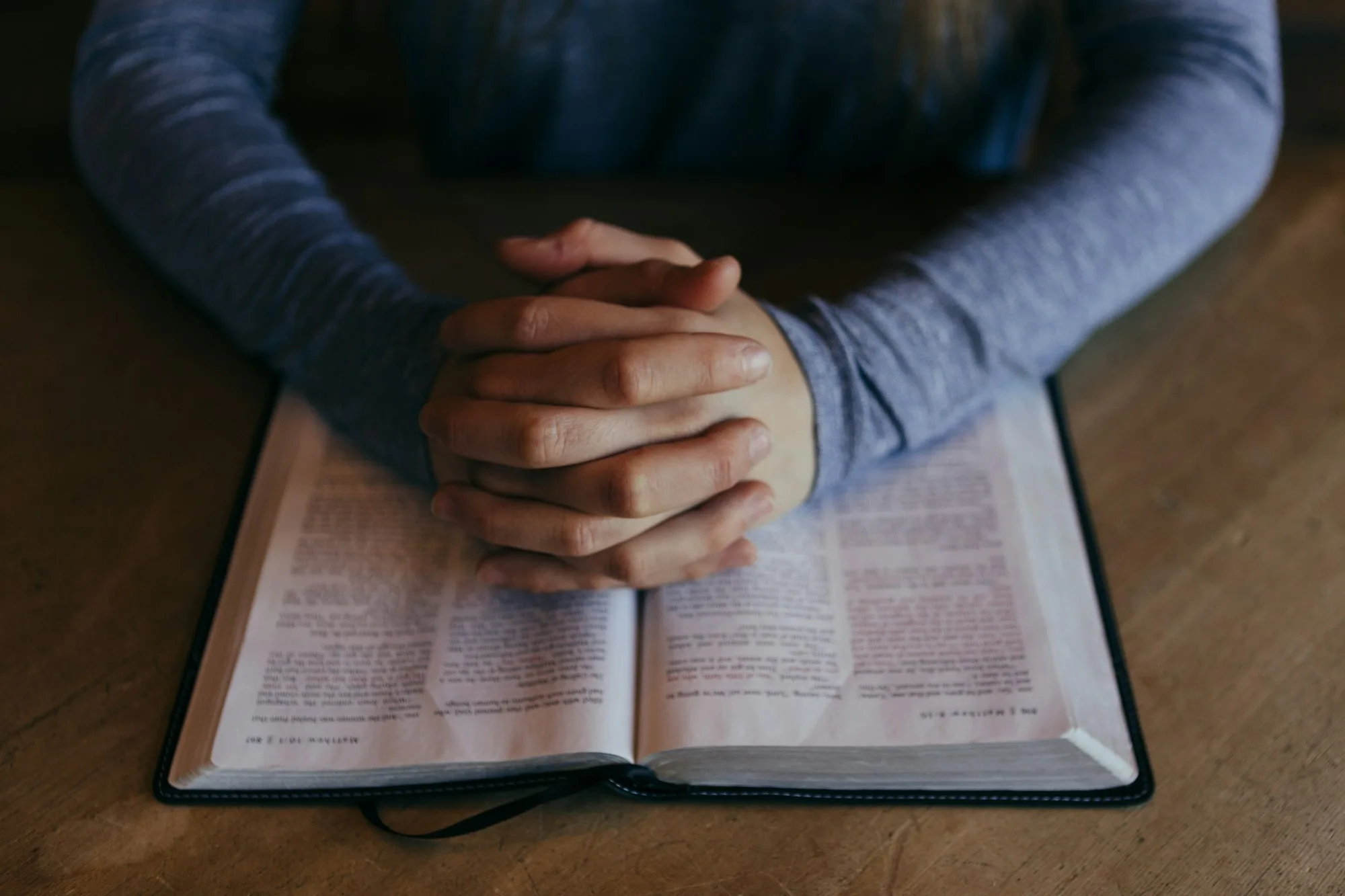 Hands resting on an open Bible