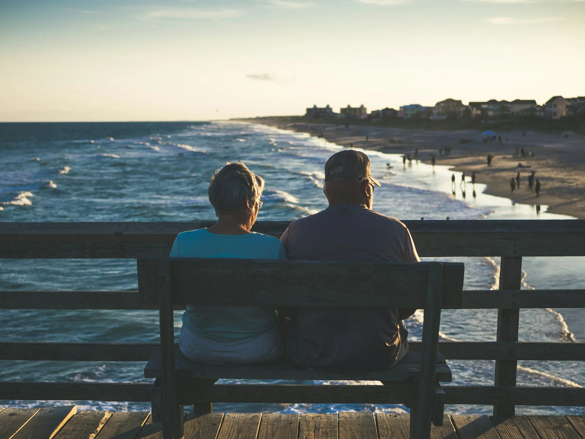 Retired couple sitting on a bench overlooking the water